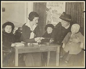 Widow Buys $10 Irish Bond. Miss Margaret Walsh of the Irish bond headquarters staff, delivering a $10 certificate to Mrs. Mary Burns of Walpole. Mrs. Burns, a widow, made a special trip with her three small children to the American House to take out a bond.