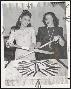 “Give a Knife, Save a Soldier’s Life” is the slogan of the knife-collecting drive started in Cambridge by Peter Christy, Harvard square restaurant owner. Christy, owner of a rare collection of American and foreign knives, will donate them all to U. S. Army rangers. The pretty posers are Irene O’Leary and Marie Emery, both of Cambridge.