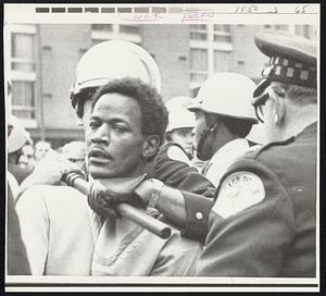 Chicago Policeman subdues demonstrator outside U.S. Customs House yesterday as Labor Department officials held hearing into charges of racial discrimination on federally financed constructor projects.