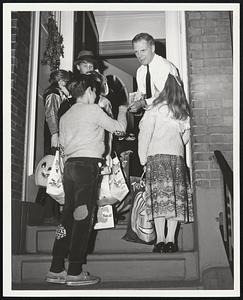 Halloween Canvassers Pay a Visit to Kevin White, Boston candidate for Mayor, who takes a pause at his home from his busy campaign schedule to say hello to some of the costumes children out last night to "trick-or-treat."