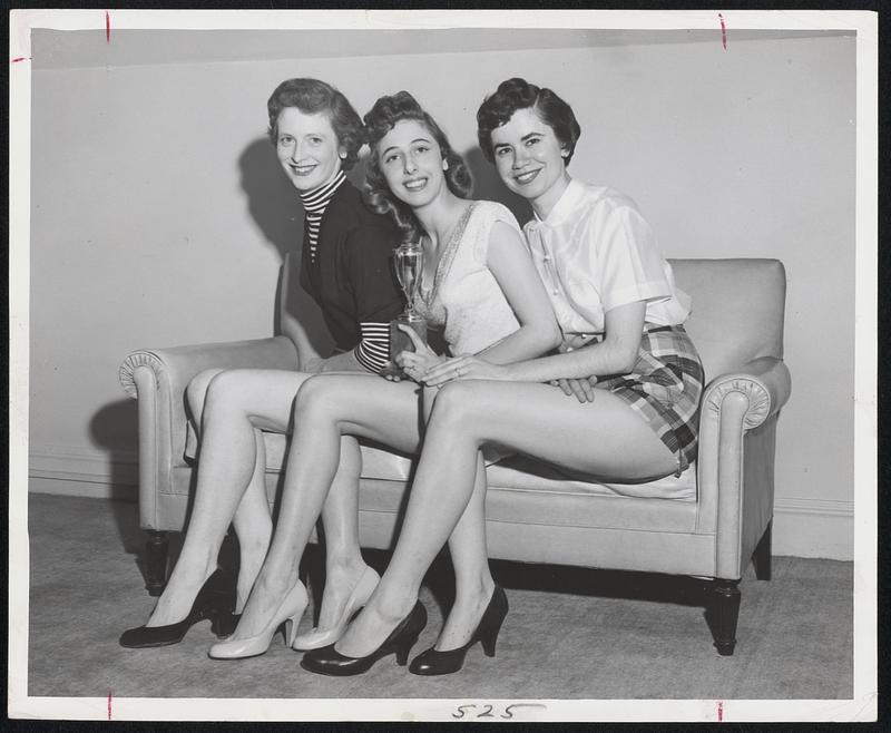 Hub's Most Beautiful Legs honor went to pretty 19-year-old Diana Zaffiro of Everett (center) who tapped the recent competition inspired by the movie "Daddy Long Legs." Miss Zaffiro received a trophy and year's supply of Bur-Mil. Runner-up's Mrs. Barbara Crosby, South Weymouth (left), and Miss Diane Griffin, South Boston (right), receive a month's supply of hosiery. Dorothy Frame, special consultant for the company, who picked the winner, is in Filene's hosiery department today.