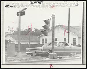 A traffic light, dangling by its wire, swings wildly in the wind, as Corpus Christi resident drive by for a look at the city following the passage of Hurricane Celia. The hurricane with 115 mph winds passed over here late 8/3 causing considerable damage in the area.