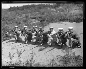 A row of men in uniform, some wearing caps which read A.R.A. Rivadavia, kneel holding rifles in firing position