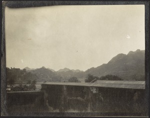 View of high wall, possibly a dam; mountains in distance