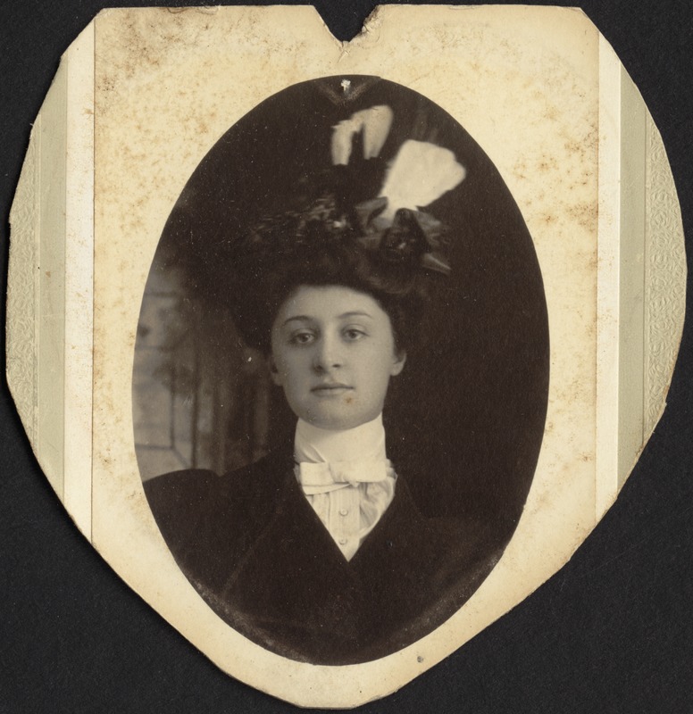 Portrait of a young woman in hat, black dress and stiff high collar