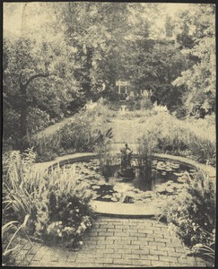 Flower garden with pool with brick path and sculpture