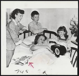 Trying to Listen to Dad's Victory is Sandra Savold, 12, daughter of Boxer Lee Savold, who last night defeated Bruce Woodcock to win the British and European versions of the heavyweight title. Sandra bedded by an appendectomy, was unable to tune in the fight. Standing around the hospital bed, left to right, are Mrs. Savold, Dick, 15, and Sharon, 7.
