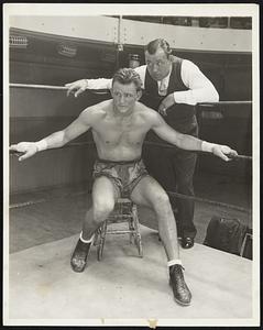 Sharkey Gives his Man Some Pointers. Jack Sharkey of Boston, Mass., who boxes a little now and then, is now managing Ernie Schaaf who meets Victorio Campolo, the Argentine boxer, in Brooklyn, N.Y., August 26, and is shown at a New York Gymnasium August 25 whispering a few words of counsel to Schaaf who is working out at the gym. The bout with Campolo is booked for 12 rounds.