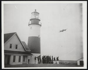 Coast Guardsmen Greet Flying Santa. Coast Guardsmen station at Sankaty Head lighthouse on Nantucket Island wave a greeting to the plane bearing Edward Rowe Snow, New England's "Flying Santa", as he visited the famous beacon today (Dec. 21). Snow, saltwater historian, annually drops Christmas packages to lighthouse keepers and their families along the seacoast.