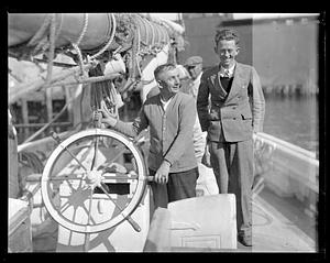 Angus Walters, captain of the "Bluenose" holding the wheel of a ship next to taller unidentified man