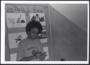 Boy standing in front of a book project display