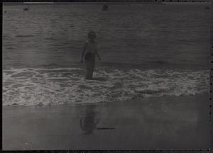 A woman standing in the surf at the beach