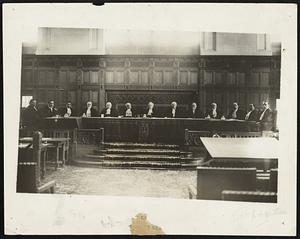 The Court Which is to Form One of the Planks in the Harding Campaign The permanent World Court in full session at The Hague. The German Judge, Professor Walt[h]er Schucking is seated at the extreme left. Second from the extreme right is the new deputy Judge Wang Chung Hui from China. Third from center to right is John Bas[sett] Moore