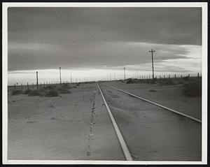 Dust Storms Again Plague the Southwest. Drifting top soil from the plains almost cover these railroad tracks after the first dust storms of 1938 in the Southwest. Authorities feared other storms would occur throughout the winter and spring because the soil was so pulverized after the droughts of the last few years.