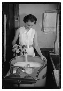 A woman doing laundry with a washing machine