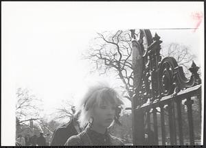 A woman walking past a gate
