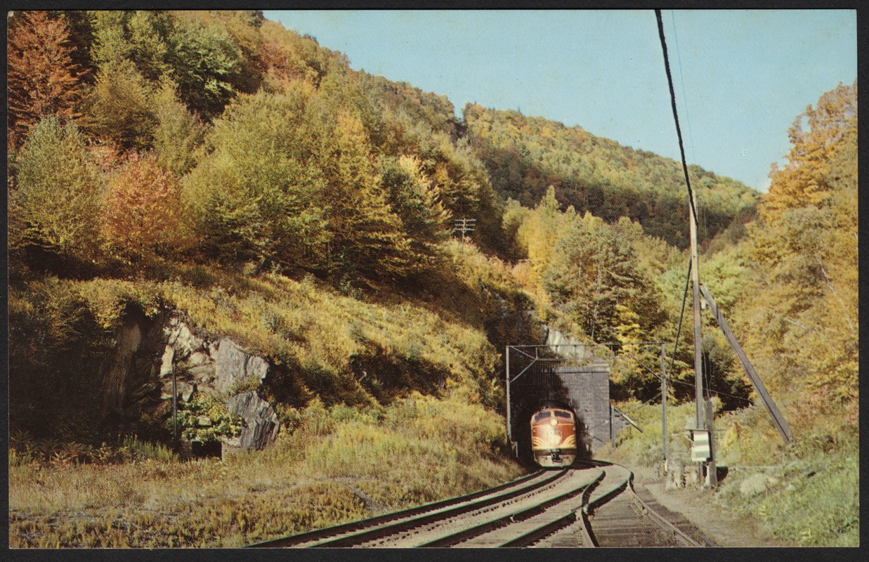 Modern diesel train emerging from east portal of historic Hoosac Tunnel