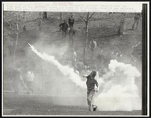 A Kent State University student tosses a tear gas bomb back at the National Guard, who fired it to disperse crowd. It was reported that four were killed and another 15 persons were wounded