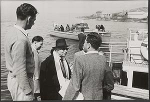 Serge Koussevitzky with a group of people, a boat in the background