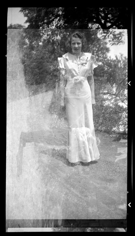 Woman in gown stands outside