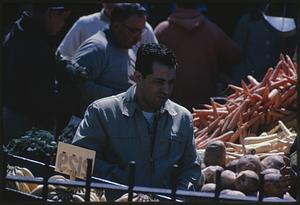 Man near produce at outdoor market