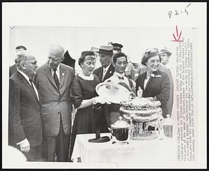 Mamie Presents Belmont Trophy--Mrs.Mamie Eisenhower presents the Belmont Stakes trophy and tray to Mrs.Jacob Sher,wife of the owner of Sherluck,winner of the Belmont Stakes today at New York’s Belmont Park. Between the two women is Jockey Braulio Baeza, who rode the longshot winner. Former President Eisenhower chats with winning owner Jacob Sher, at left.