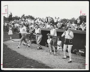 Hobo Players leap from their dugout to cheer Mrs. Thompson as she heads for the plate after putting her team back into the game with a grand-slam home-run. However, their goose was cooked by Mrs. May Cooke, who belted four homers in Snobs’ victory.
