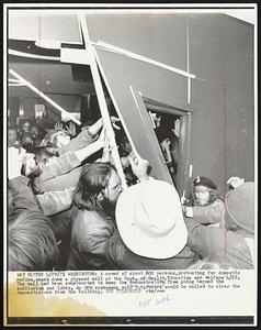A crowd of about 600 persons, protesting for domestic reform, smash down a plywood wall at the Dept. of Health, Education and Welfare 4/29. The wall had been constructed to keep the demonstrators from going beyond the auditorium and lobby. An HEW spokesman said D.C. Police would be called to clear the demonstrators from the building.