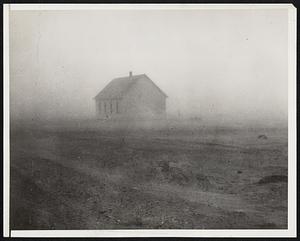 A "Black Blizzard" in the southwest. Guymon, Okla. -- Dense clouds of silt. blown by wind that sometimes reached a velocity of 55 miles an hour. All but blot out this school house during one of the series of dust storms which swept over portions of Kansas, Oklahoma and Texas the latter part of January. They were the first of the year, but agriculture authorities said there would be more unless there were heavy rains or snow to pack the pulverized soil.