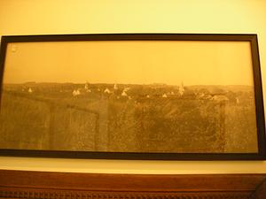 Framed photo of rural area, inluding rooves of houses and church steeples