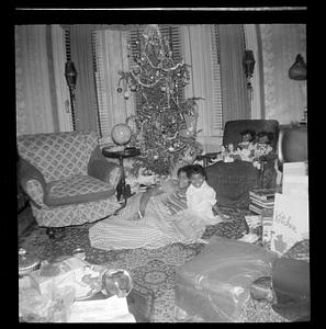 Yvonne and a girl sit in front of a Christmas tree