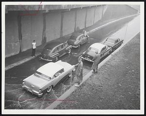 Storrow Drive Tie-Up occurred when these cars stalled near the Massachusetts underpass. Note the motorist (top center) with his engine hood up, trying to dry the spark plug and wires enough so his car would start.
