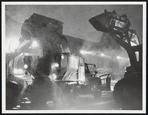 Rock salt & sand going into night - silhouetted, two loaders, loading salt & sanding trucks, Albany St., City Yard