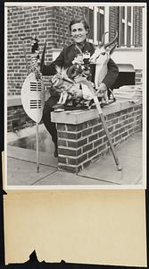 South African Field Hockey Player With Native Souvenirs. Philadelphia- Miss Kathleen Callaghan of the South African field hockey team, which is competing in the international field hockey tournament at the Philadelphia Cricket Club, shown with some souvenirs from the Transvaal. On the left is a Zulu shield and in the center a wooden lion among other native products. Her team meets the U.S. today.