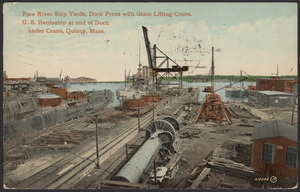Fore River Ship Yards, dock front with giant lifting crane, U.S. battleship at end of dock under crane, Quincy, Mass.