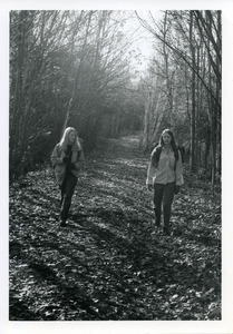 Students Ann Stift and Amy Broaddus strolling in wooded lane