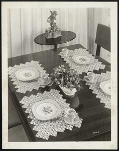 Lovely to Look At and inexpensive to make are these lacy place mats. Crochet yours in one or two colors to match your fine china. Separate, easy-to-handle squares are quickly sewn together for the unusual diamond-shaped effect and edging. For crocheting directions send a stamped, self-addressed envelope to Gloria Gould at The Boston Herald.