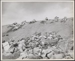 Fifth Division Marine invaders of Iwo Jima work their way up the slope from Red Beach One