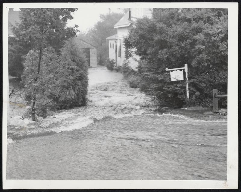 Driveway-For Boats-Water pours down into the driveway of a home in the Greenbush section of Scituate, rushing across country way from the overflowing Old Oaken Bucket pond.