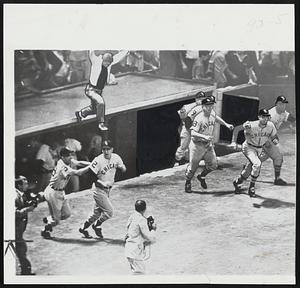 Seconds After the White Sox won their first American League pennant in 40 years. Jubilant Chicago players dash out of the dugout to congratulate the players on the field. A young unidentified fan gets into the act as he leaps from the dugout roof. Coach Don Gutteridge (left) holds onto Manager Al Lopez as they head for the field.