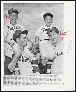 Youngsters All-Out for Phillies -- This pair of small fry, complete with uniform, were spotted by Philadelphia Phillies pitchers Dick Farrell, left, and Dallas Green during practice. Pitchers promptly hoisted kids to their shoulders for a better look at the other players. Boys are Jim, 8, and Bob, 10, right. They are sons of Mr. and Mrs. Paul Dolembo, of Michigan City, Ind., who are vacationing here and are long-time Phillies' fans. Phillies start their spring training tomorrow.