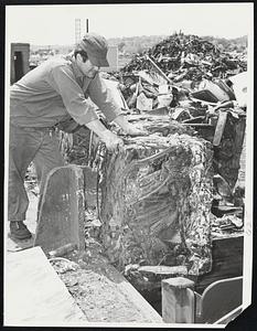 Cap's Auto Body Lynn. Crane Operator Gerald Comeau of Lynn looking over finished Products Baled auto which is ready for shipment over sea's