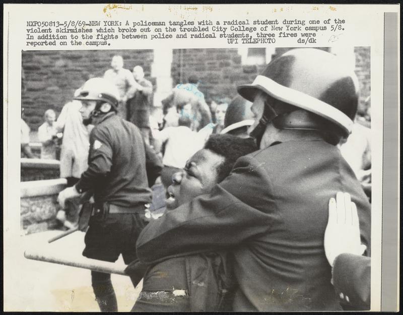 New York: A Policeman tangles with a radical student during one of the violent skirmishes which broke out on the troubled City College of New York campus 5/8. In addition to the fights between police and radical students, three fires were reported on the campus.