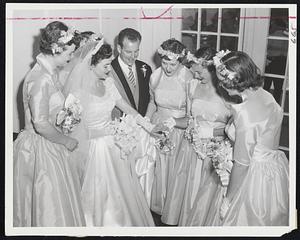 Bruins Hockey Star, Eddie Sanford, does'nt mind being edged into background as his bride, the former Helen Patricia Fairclough of Newton, shows her wedding ring to her bridesmaids during the couple's reception at Brae Burn Country Club yesterday following their wedding at St. Bernard's Church, West Newton.