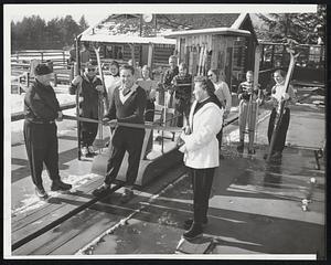 Ski Season opens at North Conway, N. H., with ribbon cutting ceremony at the Skimobile. Cutting ribbon is Herbert Schneider who heads ski school at Cranmore Mt. Aiding him is Don Garnett (left) and Miss Ruth Leslie.