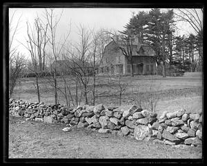 A low stone wall, a house in the background