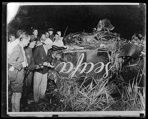 Spectators surround wreckage of an unidentified accident