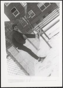 Val leaning against a fence