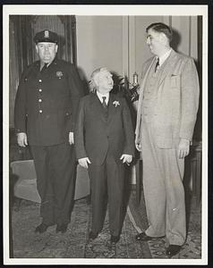 The Vice-President Yields. Vice-President Garner weighs 170 pounds and is five feet, eight and one-half inches tall, but he felt like a shrimp April 7 when he found himself between two giants, policeman Edward F. “Tiny” Brown (left), assigned to his office, and B.W. Carier, 27-year-old Buffalo Resident. Carier weighs 320 pounds and is seven feet, two inches tall. Policeman Brown tips the beam at 328 and is six feet, nine and a half in height.