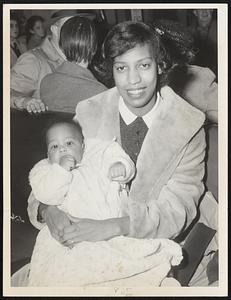 On Hand To Greet hubby Bill Russell of the Boston Celtics when he arrived yesterday at Boston Airport from St. LOuis were his wife, Rose, and five-month-old son William Jr. Their Reading home was ransacked over the weekend and Bill is still nursing a tender ankle, but everything probably seemed all right when the Celtics Magnificent Rebounder saw this sight.